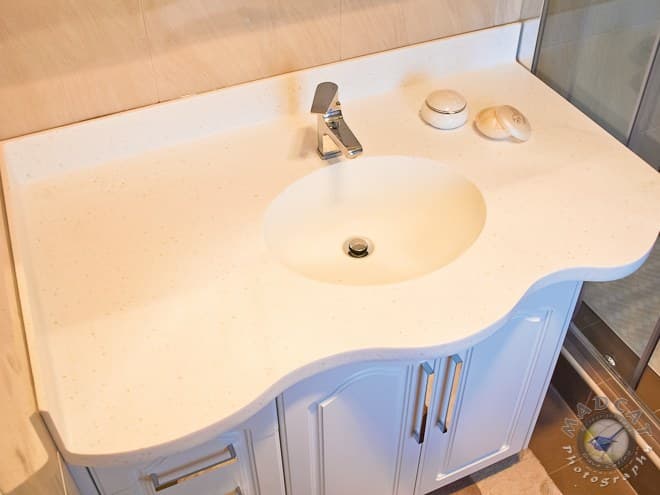 Bathroom vanity with a moulded stone benchtop, chrome tapware and an inset oval basin